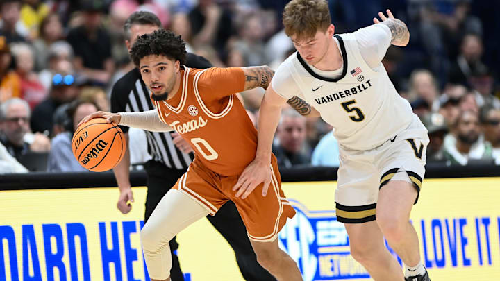 Texas Longhorns guard Jordan Pope (0) drives up court past Vanderbilt Commodores guard Tyler Nickel (5) during the first half at Bridgestone Arena in Nashville, Tenn., Wednesday, March 12, 2025.