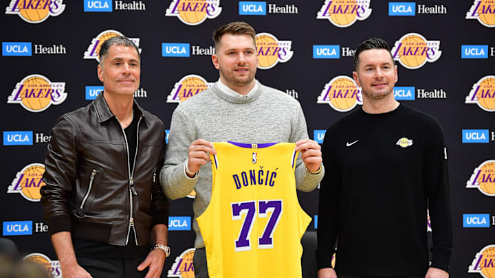 Los Angeles Lakers guard Luka Doncic poses for photos with general manager Rob Pelinka and head coach JJ Redick.