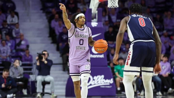 Feb 11, 2025; Manhattan, Kansas, USA; Kansas State Wildcats guard Dug McDaniel (0) brings the ball up court against Arizona Wildcats guard Jaden Bradley (0) during the first half at Bramlage Coliseum. Mandatory Credit: Scott Sewell-Imagn Images