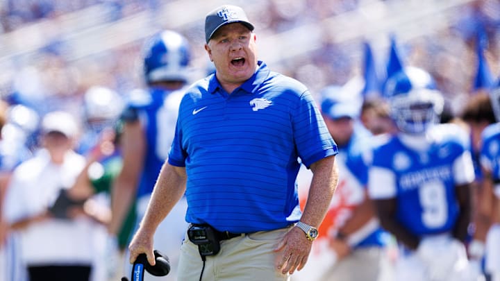 Aug 30, 2025; Lexington, Kentucky, USA; Kentucky Wildcats head coach Mark Stoops discusses a play with a referee during the first quarter against the Toledo Rockets at Kroger Field. Mandatory Credit: Jordan Prather-Imagn Images