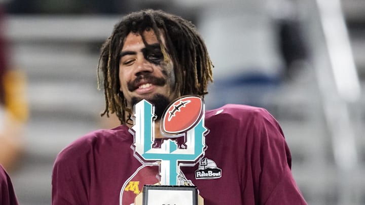 Dec 26, 2025; Phoenix, AZ, USA; Minnesota Gophers defensive lineman Anthony Smith celebrates with the trophy after defeating the New Mexico Lobos in overtime of the Rate Bowl at Chase Field. Mandatory Credit: Mark J. Rebilas-Imagn Images