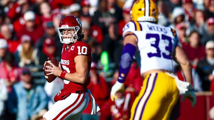 Nov 29, 2025; Norman, Oklahoma, USA; Oklahoma Sooners quarterback John Mateer (10) throws as Louisiana State Tigers linebacker West Weeks (33) defends during the first half at Gaylord Family-Oklahoma Memorial Stadium. Mandatory Credit: Kevin Jairaj-Imagn Images Nov 29, 2025; Norman, Oklahoma, USA; Oklahoma Sooners quarterback John Mateer (10) throws as Louisiana State Tigers linebacker West Weeks (33) defends during the first half at Gaylord Family-Oklahoma Memorial Stadium. Mandatory Credit: Kevin Jairaj-Imagn Images