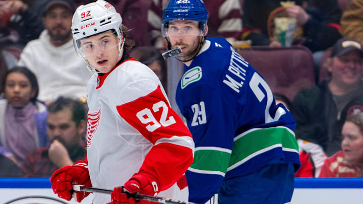 Feb 2, 2025; Vancouver, British Columbia, CAN; Detroit Red Wings forward Marco Kasper (92) and Vancouver Canucks defenseman Marcus Pettersson (29) watch the flying puck in the second period at Rogers Arena. Mandatory Credit: Bob Frid-Imagn Images
