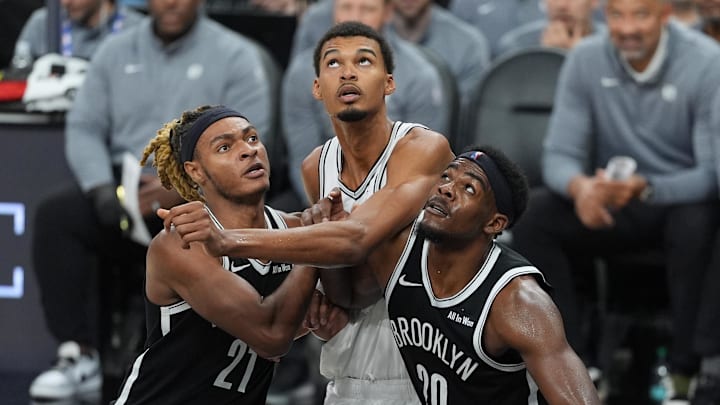Oct 26, 2025; San Antonio, Texas, USA; Brooklyn Nets forward Noah Clowney (21) and center Day'Ron Sharpe (20) push San Antonio Spurs forward Victor Wembanyama (1) back in the second half at Frost Bank Center. Mandatory Credit: Daniel Dunn-Imagn Images