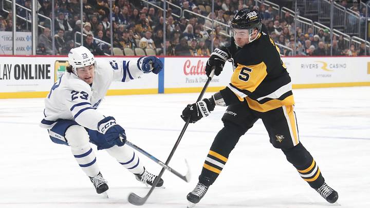 Mar 2, 2025; Pittsburgh, Pennsylvania, USA;  Pittsburgh Penguins defenseman Ryan Shea (5) shoots the puck as Toronto Maple Leafs left wing Matthew Knies (23) defends during the first period at PPG Paints Arena. Mandatory Credit: Charles LeClaire-Imagn Images