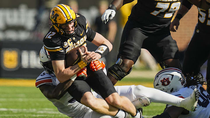 Oct 19, 2024; Columbia, Missouri, USA; Missouri Tigers quarterback Brady Cook (12) is tackled by Auburn Tigers nose tackle Jalen McLeod (35) during the first half at Faurot Field at Memorial Stadium. Mandatory Credit: Jay Biggerstaff-Imagn Images