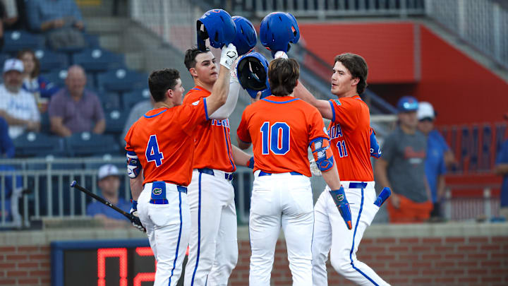 Cade Kurland (4), Luke Heyman (28) and Colby Shelton (10) celebrate with Brendan Lawson (11) after the freshman's three-run home run against Jacksonville. The Florida Gators would go on to win 16-4.