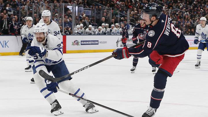 Nov 26, 2025; Columbus, Ohio, USA; Columbus Blue Jackets defenseman Zach Werenski (8) wrists a shot on goal as Toronto Maple Leafs center Nicolas Roy (55) defends during the second period at Nationwide Arena. Mandatory Credit: Russell LaBounty-Imagn Images