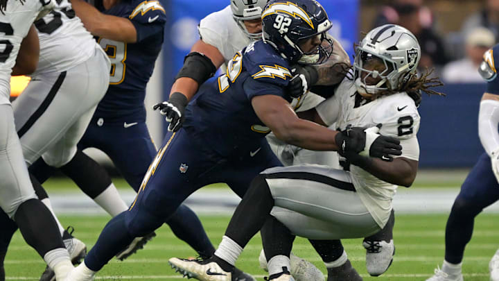 Nov 30, 2025; Inglewood, California, USA; Los Angeles Chargers defensive tackle Justin Eboigbe (92) tackles Las Vegas Raiders running back Ashton Jeanty (2) during the second half at SoFi Stadium. Nov 30, 2025; Inglewood, California, USA; Los Angeles Chargers defensive tackle Justin Eboigbe (92) tackles Las Vegas Raiders running back Ashton Jeanty (2) during the second half at SoFi Stadium.