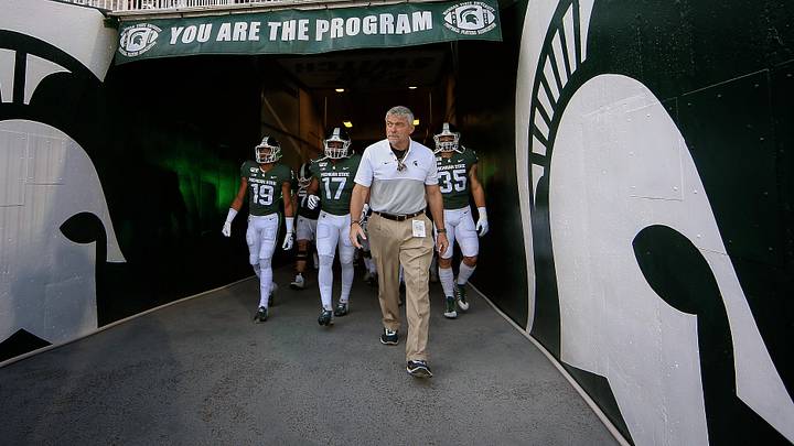 Aug 30, 2019; East Lansing, MI, USA; Michigan State Spartans head strength and conditioning coach Ken Mannie leads the Spartan defense out of the tunnel prior to a game against the Tulsa Golden Hurricane at Spartan Stadium. Mandatory Credit: Mike Carter-Imagn Images