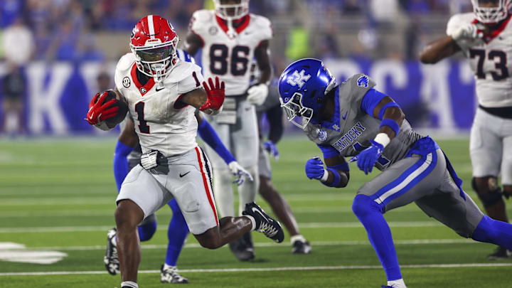 Sep 14, 2024; Lexington, Kentucky, USA; Georgia Bulldogs running back Trevor Etienne (1) and Kentucky Wildcats defensive back Kristian Story (4) during the second half at Kroger Field. Georgia won 13-12. Mandatory Credit: Carter Skaggs-Imagn Images