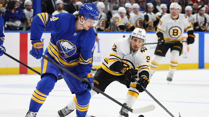 Mar 25, 2026; Buffalo, New York, USA;  Buffalo Sabres defenseman Bowen Byram (4) looks to control the puck as Boston Bruins center Marat Khusnutdinov (92) defends during the third period at KeyBank Center. Mandatory Credit: Timothy T. Ludwig-Imagn Images