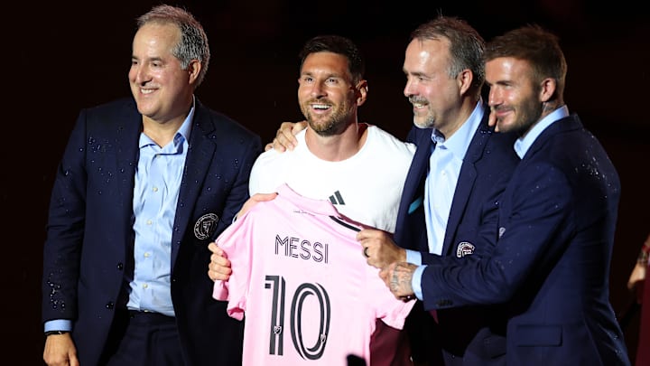 Lionel Messi holds his new Inter Miami CF jersey while club co-owners Jorge Mas, Jose Mas and David Beckham pose with the Herons' new captain in June 2023.