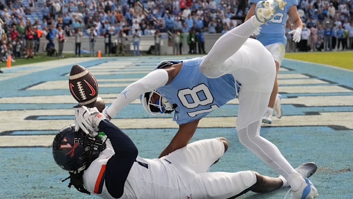 Oct 25, 2025; Chapel Hill, North Carolina, USA; North Carolina Tar Heels defensive back Jaiden Patterson (18) breaks up a pass in the end zone intended for Virginia Cavaliers wide receiver Jahmal Edrine (7) in overtime at Kenan Stadium. Mandatory Credit: Bob Donnan-Imagn Images