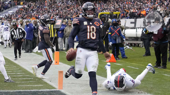 Nov 9, 2025; Chicago, Illinois, USA; Chicago Bears quarterback Caleb Williams (18) scores the game-winning touchdown against New York Giants linebacker Brian Burns (0) during the fourth quarter at Soldier Field. Mandatory Credit: David Banks-Imagn Images