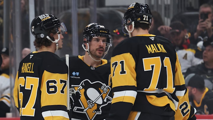 Apr 13, 2025; Pittsburgh, Pennsylvania, USA;  Pittsburgh Penguins right wing Rickard Rakell (67) and center Sidney Crosby (87) and center Evgeni Malkin (71) talk before a face-off against the Boston Bruins during the third period at PPG Paints Arena. Mandatory Credit: Charles LeClaire-Imagn Images