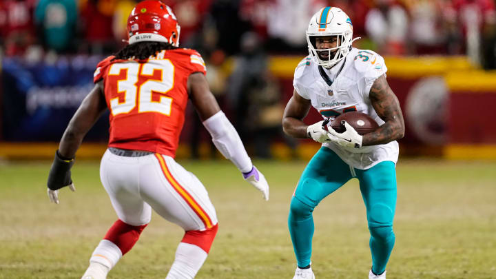 Jan 13, 2024; Kansas City, Missouri, USA; Miami Dolphins running back Raheem Mostert (31) runs the ball against Kansas City Chiefs linebacker Nick Bolton (32) during the second half of a 2024 AFC wild card game at GEHA Field at Arrowhead Stadium. Mandatory Credit: Jay Biggerstaff-USA TODAY Sports
