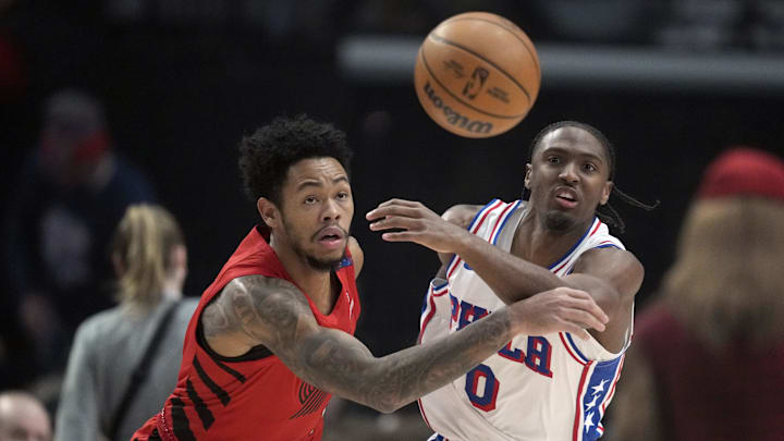 Dec 30, 2024; Portland, Oregon, USA; Portland Trail Blazers shooting guard Anfernee Simons (1, left) and Philadelphia 76ers point guard Tyrese Maxey (0) go for a loose ball during the first half at Moda Center. Mandatory Credit: Soobum Im-Imagn Images