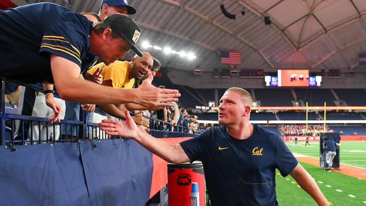Cal coach Tosh Lupoi celebrates with fans at Syracuse