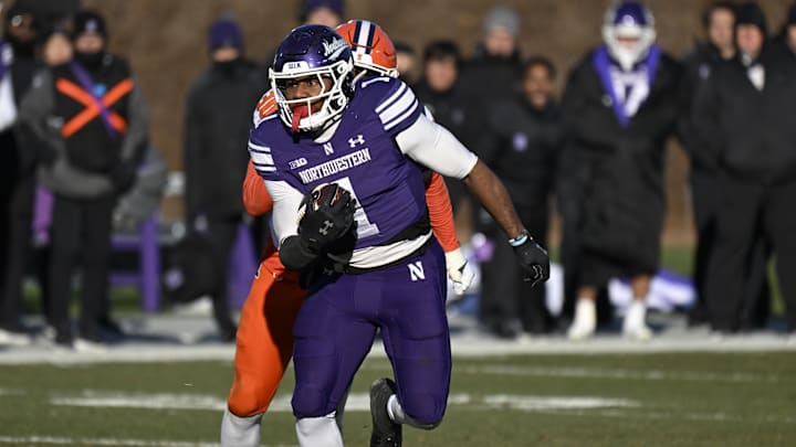Nov 30, 2024; Chicago, Illinois, USA;  Northwestern Wildcats running back Cam Porter (1) runs the ball against the Illinois Fighting Illini during the second half at Wrigley Field. Mandatory Credit: Matt Marton-Imagn Images