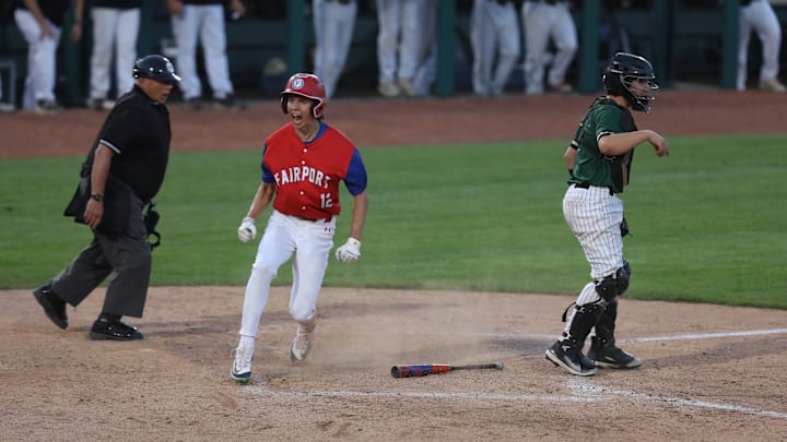 Fairport's Samuel Roselli yells after scoring on a bunt by a teammate