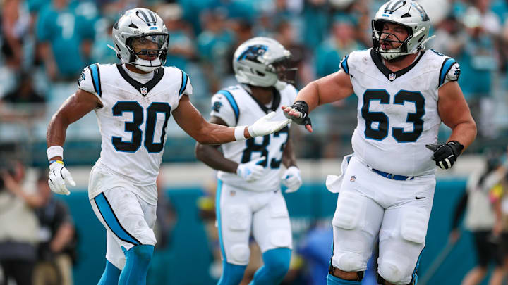 Sep 7, 2025; Jacksonville, Florida, USA; Carolina Panthers running back Chuba Hubbard (30) and center Austin Corbett (63) celebrate a touchdown against the Jacksonville Jaguars during the second half at EverBank Stadium. 