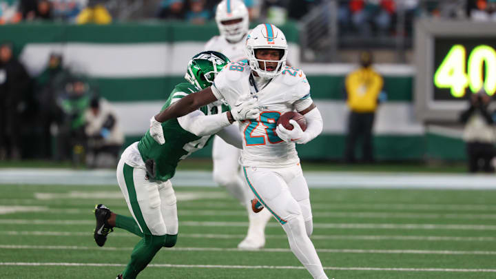 Jan 5, 2025; East Rutherford, New Jersey, USA; Miami Dolphins running back De'Von Achane (28) runs with the ball while New York Jets cornerback D.J. Reed (4) attempts to tackle him during the first quarter at MetLife Stadium. Mandatory Credit: Ed Mulholland-Imagn Images Jan 5, 2025; East Rutherford, New Jersey, USA; Miami Dolphins running back De'Von Achane (28) runs with the ball while New York Jets cornerback D.J. Reed (4) attempts to tackle him during the first quarter at MetLife Stadium. Mandatory Credit: Ed Mulholland-Imagn Images