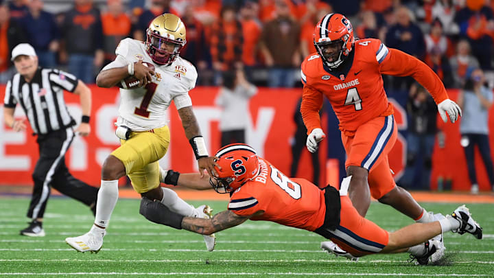 Nov 3, 2023; Syracuse, New York, USA; Boston College Eagles quarterback Thomas Castellanos (1) runs with the ball as Syracuse Orange defensive lineman Caleb Okechukwu (4) and defensive back Justin Barron (8) try to make the tackle during the second half at the JMA Wireless Dome. Mandatory Credit: Rich Barnes-Imagn Images