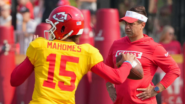 Jul 26, 2024; Kansas City, MO, USA; Kansas City Chiefs quarterback Patrick Mahomes (15) throws a pass as general manager Brett Veach watches in the background during training camp at Missouri Western State University. Mandatory Credit: Denny Medley-Imagn Images