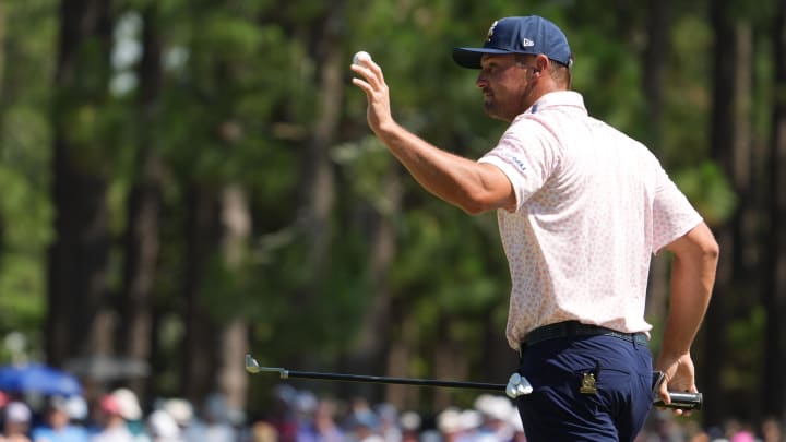 Jun 15, 2024; Pinehurst, North Carolina, USA; Bryson DeChambeau waves to the gallery after putting on the first green during the third round of the U.S. Open golf tournament. Mandatory Credit: John David Mercer-USA TODAY Sports