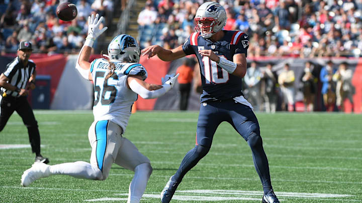 Sep 28, 2025; Foxborough, Massachusetts, USA; New England Patriots quarterback Drake Maye (10) passes the ball past Carolina Panthers linebacker Christian Rozeboom (56) during the second half at Gillette Stadium. Mandatory Credit: Bob DeChiara-Imagn Images