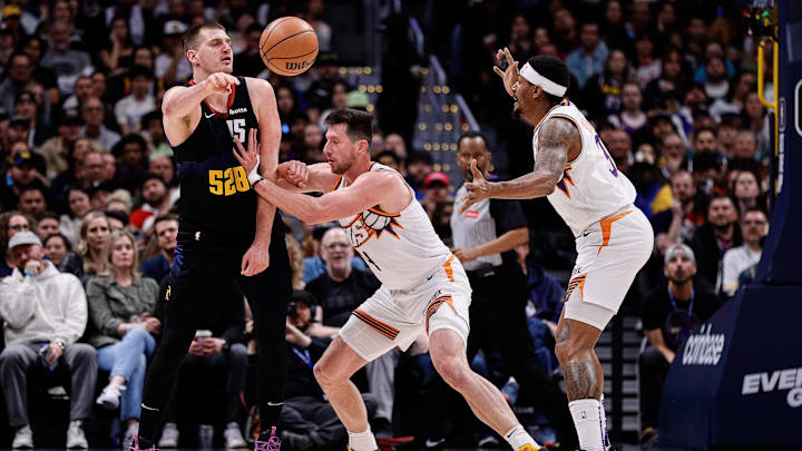 Mar 27, 2024; Denver, Colorado, USA; Denver Nuggets center Nikola Jokic (15) passes the ball against Phoenix Suns forward Drew Eubanks (14) and guard Bradley Beal (3) in the third quarter at Ball Arena. Mandatory Credit: Isaiah J. Downing-Imagn Images