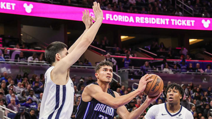 Feb 21, 2025; Orlando, Florida, USA; Orlando Magic forward Tristan da Silva (23) passes the ball in front of Memphis Grizzlies center Zach Edey (14) during the second quarter at Kia Center. Mandatory Credit: Mike Watters-Imagn Images