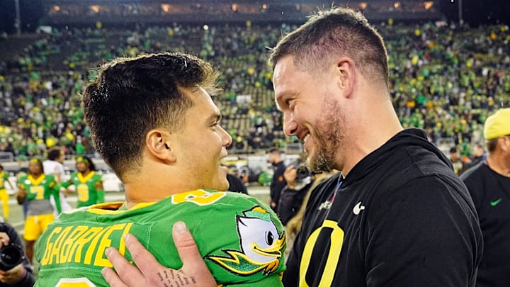 Oregon quarterback Dillon Gabriel, left, and coach Dan Lanning embrace after defeating Maryland at Autzen Stadium. Oregon quarterback Dillon Gabriel, left, and coach Dan Lanning embrace after defeating Maryland at Autzen Stadium.