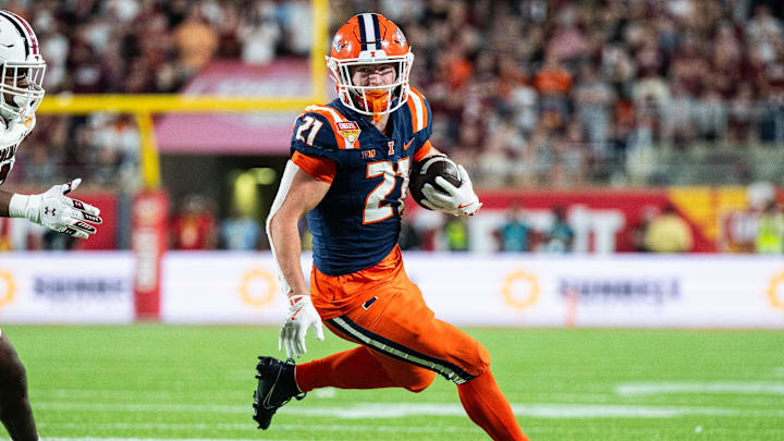 Dec 31, 2024; Orlando, FL, USA; Illinois Fighting Illini running back Aidan Laughery (21) runs the ball against South Carolina Gamecocks linebacker Debo Williams (0) in the fourth quarter at Camping World Stadium. Mandatory Credit: Jeremy Reper-Imagn Images
