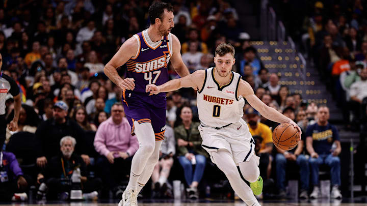 Oct 13, 2024; Denver, Colorado, USA; Denver Nuggets guard Christian Braun (0) dribbles the ball up court ahead of Phoenix Suns forward Frank Kaminsky (47) in the fourth quarter at Ball Arena. Mandatory Credit: Isaiah J. Downing-Imagn Images
