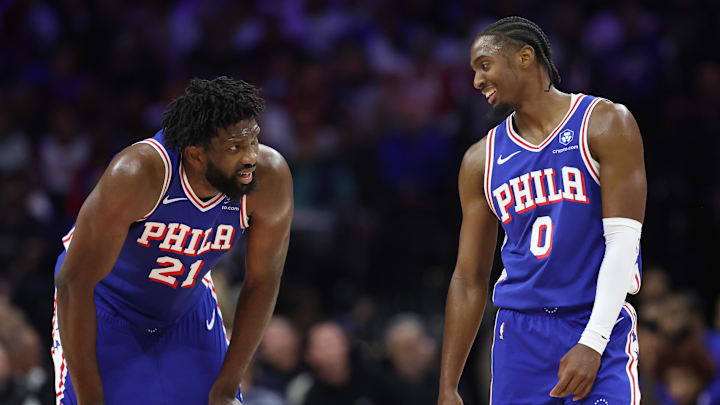 Oct 25, 2025; Philadelphia, Pennsylvania, USA; Philadelphia 76ers guard Tyrese Maxey (0) and center Joel Embiid (21) talks during a break in action in the second quarter against the Charlotte Hornets at Xfinity Mobile Arena. Mandatory Credit: Bill Streicher-Imagn Images