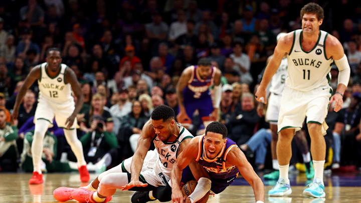 Mar 24, 2025; Phoenix, Arizona, USA; Milwaukee Bucks forward Giannis Antetokounmpo (34) and Phoenix Suns guard Devin Booker (1) go for the ball during the fourth quarter at Footprint Center. Mandatory Credit: Mark J. Rebilas-Imagn Images