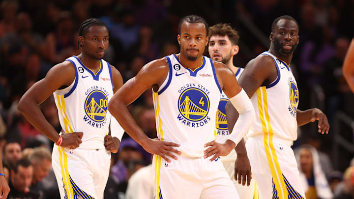 Golden State Warriors guard Moses Moody (4), forward Jonathan Kuminga (00) and forward Draymond Green (23) against the Phoenix Suns at Footprint Center. Mandatory Credit: Mark J. Rebilas-Imagn Images