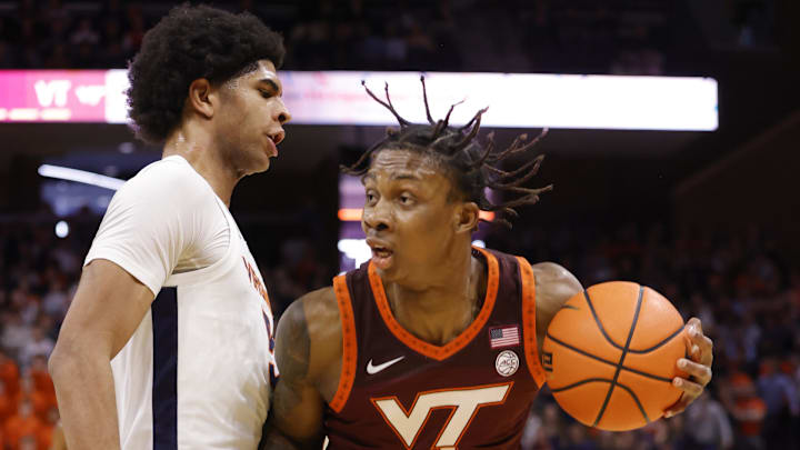 Feb 1, 2025; Charlottesville, Virginia, USA; Virginia Tech Hokies forward Tobi Lawal (1) controls the ball as Virginia Cavaliers forward Jacob Cofie (5) defends in the first half at John Paul Jones Arena. Mandatory Credit: Amber Searls-Imagn Images