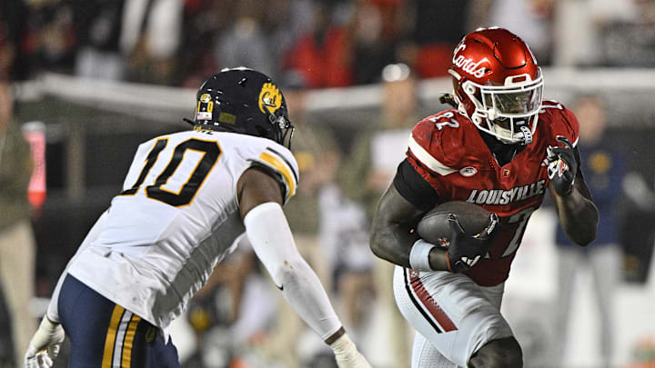 Nov 8, 2025; Louisville, Kentucky, USA;  Louisville Cardinals running back Keyjuan Brown (22) runs the ball against California Golden Bears linebacker Jayden Wayne (10) in overtime at L&N Federal Credit Union Stadium. California defeated Louisville 29-26. Mandatory Credit: Jamie Rhodes-Imagn Images