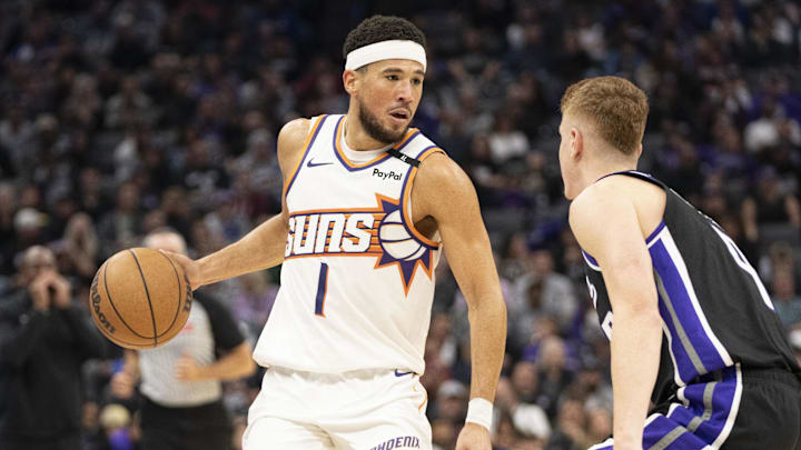 November 13, 2024; Sacramento, California, USA; Phoenix Suns guard Devin Booker (1) dribbles the basketball against Sacramento Kings guard Kevin Huerter (9) during the third quarter at Golden 1 Center. Mandatory Credit: Kyle Terada-Imagn Images