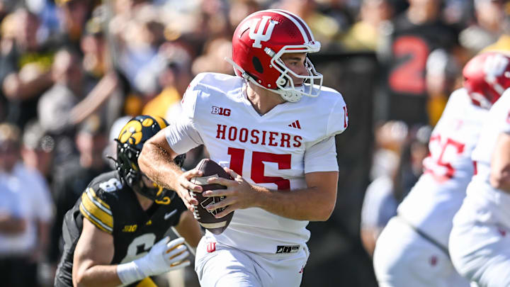 Sep 27, 2025; Iowa City, Iowa, USA; Indiana Hoosiers quarterback Fernando Mendoza (15) rolls out to throw a pass against the Iowa Hawkeyes during the first quarter at Kinnick Stadium. Mandatory Credit: Jeffrey Becker-Imagn Images