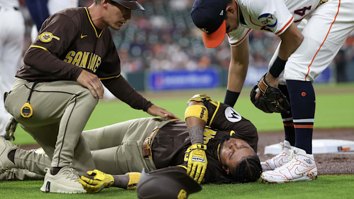 Apr 20, 2025; Houston, Texas, USA;San Diego Padres first base coach David Macias (46) and Houston Astros second baseman Mauricio Dubon (14) check on San Diego Padres designated hitter Luis Arraez (4) as he lies on the field after colliding with Houston Astros first baseman Christian Walker (8) (not pictured )on the first base line in the first inning at Daikin Park. Mandatory Credit: Thomas Shea-Imagn Images Apr 20, 2025; Houston, Texas, USA;San Diego Padres first base coach David Macias (46) and Houston Astros second baseman Mauricio Dubon (14) check on San Diego Padres designated hitter Luis Arraez (4) as he lies on the field after colliding with Houston Astros first baseman Christian Walker (8) (not pictured )on the first base line in the first inning at Daikin Park. Mandatory Credit: Thomas Shea-Imagn Images