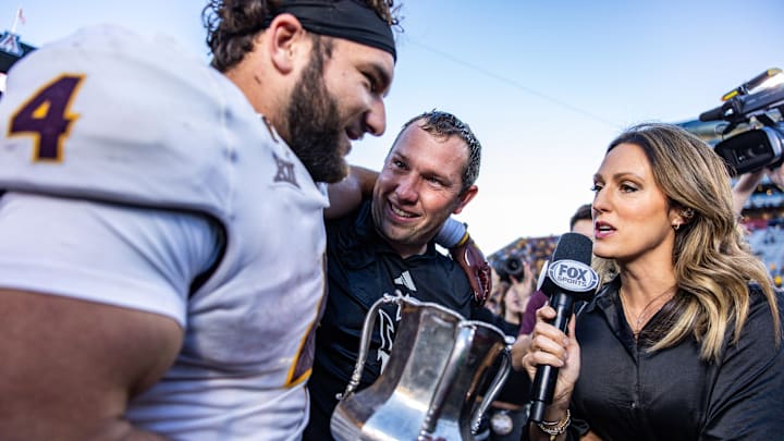 Arizona State Sun Devils running back Cam Skattebo (4) holds the Territorial Cup alongside Arizona State Sun Devils head coach Kenny Dillingham at the end of the game against the Arizona Wildcats at Arizona Stadium. 