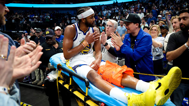 Mar 23, 2026; Dallas, Texas, USA; Golden State Warriors guard Moses Moody (4) waves to fans while leaving the court on a stretcher during overtime against the Dallas Mavericks at American Airlines Center. Mar 23, 2026; Dallas, Texas, USA; Golden State Warriors guard Moses Moody (4) waves to fans while leaving the court on a stretcher during overtime against the Dallas Mavericks at American Airlines Center.
