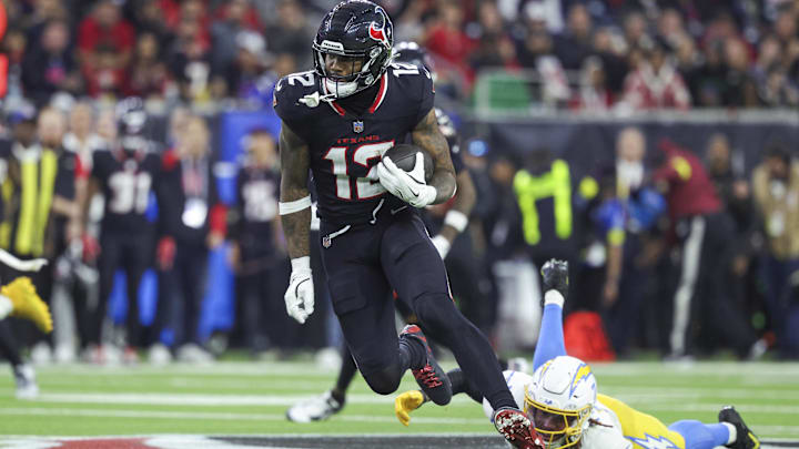 Jan 11, 2025; Houston, Texas, USA; Houston Texans wide receiver Nico Collins (12) runs with the ball after a reception during the game against the Los Angeles Chargers in an AFC wild card game at NRG Stadium.