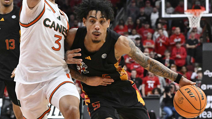 Feb 8, 2025; Louisville, Kentucky, USA;  Louisville Cardinals guard Terrence Edwards Jr. (5) dribbles against Miami (Fl) Hurricanes guard Jalil Bethea (3) during the second half at KFC Yum! Center. Louisville defeated Miami 88-78. 