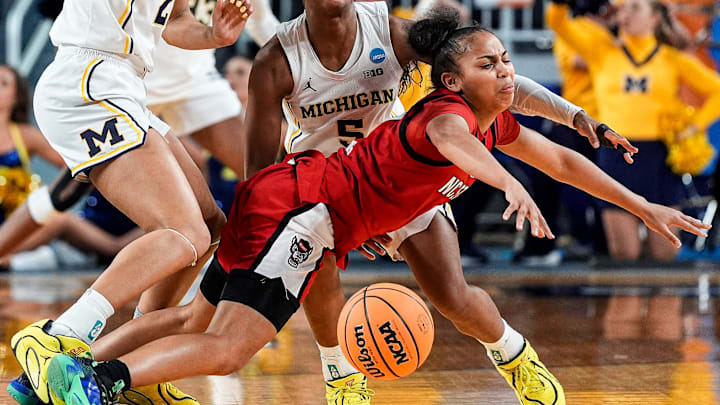 Michigan forward Kendall Dudley (22) and guard Brooke Q. Daniels (5) defend N.C. State guard Zamareya Jones (3) during the first half of the NCAA Tournament Second Round at Crisler Center in Ann Arbor on Sunday, March 22, 2026.