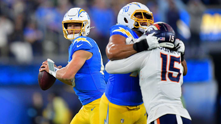 Dec 19, 2024; Inglewood, California, USA; Los Angeles Chargers quarterback Justin Herbert (10) drops back to pass as offensive tackle Rashawn Slater (70) provides coverage against Denver Broncos linebacker Nik Bonitto (15) during the second half at SoFi Stadium. 